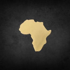 May include: A gold-colored metal outline of the continent of Africa. The outline is on a black background.