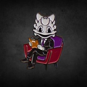 Puede incluir: Pin metálico con un personaje de rana de dibujos animados con traje, sentado en un sillón rojo y morado. La rana sostiene una carpeta con las letras "TCU". El pin tiene una combinación de colores negro, blanco y morado.