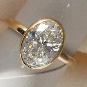Anillo solitario de moissanita ovalada de 2 quilates con detalle de zafiro azul en plata de ley.