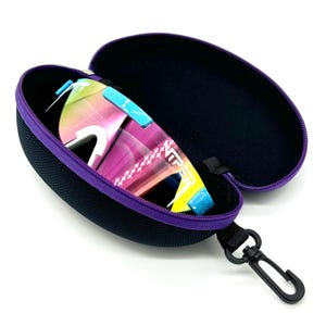 May include: A purple hard-shell case with a zipper closure and a black carrying strap. The case is open and contains a pair of colorful sunglasses with a rainbow-like pattern.