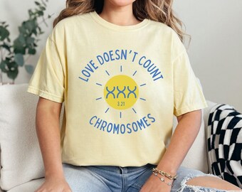 Könnte beinhalten: Ein gelbes T-Shirt mit einem Grafikdruck einer Sonne mit dem Text "Love Doesn't Count Chromosomes" und der Zahl "3.21" in der Sonne.