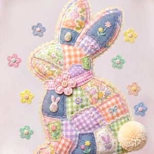 May include: A pale pink sweatshirt with a patchwork rabbit design. The rabbit is crafted from assorted floral and gingham fabrics, with a pom-pom tail and flower embellishments. Pastel-coloured flower appliqués surround the rabbit.