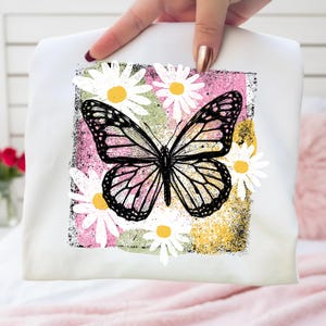 Peut inclure: Taie d'oreiller blanche avec un motif de papillon noir et blanc, sur fond rose, jaune et vert. Le papillon est entour&eacute; de marguerites blanches &agrave; c&oelig;ur jaune. Le motif est sur un fond carr&eacute;.
