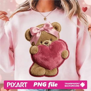 May include: Pink sweatshirt featuring a teddy bear holding a heart. The teddy bear has a pink bow and is holding a red heart. The image also includes the text "PIXART PNG file TRANSPARENT BACKGROUND".