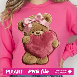 May include: A pink sweatshirt featuring a teddy bear design. The bear is brown with a pink bow and is holding a pink heart. The image also includes the text "PIXART PNG file TRANSPARENT BACKGROUND".