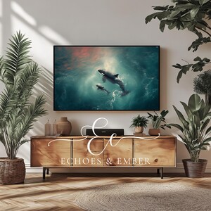 Könnte beinhalten: Eine Holz-Medienkonsole mit vier Schubladen und schwarzen Metallbeinen. Die Konsole ist mit dem Text "Echoes & Ember" verziert. Ein Fernseher ist über der Konsole montiert und zeigt ein Foto von zwei Orcas, die im Meer schwimmen.
