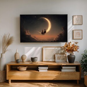 May include: A large framed print of a couple sitting on a crescent moon against a starry night sky. The artwork is displayed above a wooden cabinet with decorative items, including vases and framed pictures. The room has a neutral color palette.