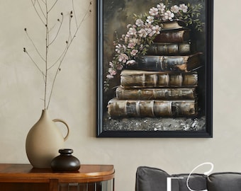 Op de afbeelding: Een ingelijst schilderij van een stapel oude boeken met een bloemstuk van roze bloemen die langs de zijkant naar beneden vallen. Het schilderij is tegen een donkere achtergrond geplaatst en heeft een zwarte lijst.