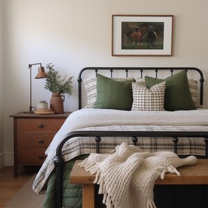 A moody equestrian painting in English countryside style hangs in a cottage bedroom.