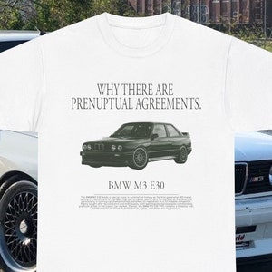 May include: White t-shirt with a black and green BMW M3 E30 car graphic and the text "WHY THERE ARE PRENUPTIAL AGREEMENTS." The text "BMW M3 E30" is below the car graphic. The text below the car graphic describes the BMW M3 E30 model.