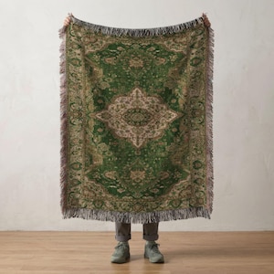 May include: A rectangular woven throw blanket featuring a deep green and beige ornate pattern with a central medallion design. The blanket has a fringed edge along all four sides and displays a complex, symmetrical floral and geometric motif.