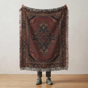 May include: A rectangular tapestry with a burgundy and navy color scheme, featuring an ornate central medallion design and decorative borders. The tapestry has a fringed edge and is held up against a neutral background.