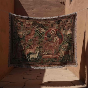 May include: A rectangular tapestry with a detailed, colorful illustration of a religious scene. The tapestry features figures, animals, and architectural elements in shades of red, green, and brown. It is hanging in a narrow, sunlit passage.