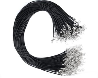 May include: A bulk pack of black leather cord with silver clasps. The cord is bundled together and the clasps are attached to the ends of the cords.
