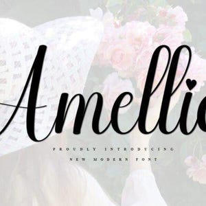 May include: A black and white image of the word "Amellia" in a cursive font with a small heart at the end of the word. The text is superimposed on a blurry image of a white hat and pink flowers.