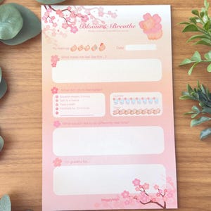 May include: A pink and white printable journal page with the title "Bloom & Breathe" and a pink flower illustration. The page includes prompts for self-reflection and gratitude.