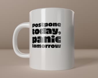 May include: White ceramic mug with a curved handle. The mug features the black text "postpone today, panic tomorrow". The words are stacked vertically. The phrase "create happiness" is at the bottom right.
