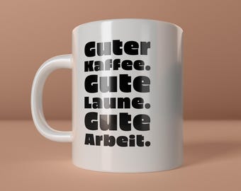 May include: White ceramic mug with the words "Guter Kaffee. Gute Laune. Gute Arbeit." in black, stacked vertically. The mug has a curved handle and the words "create happiness" are at the bottom right.