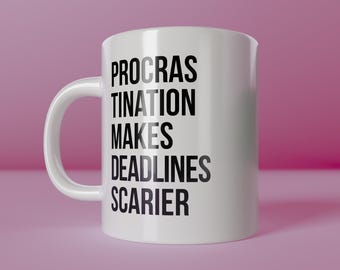 May include: White ceramic mug with the text "PROCRAS TINATION MAKES DEADLINES SCARIER" in black. The mug has a curved handle and is set against a pink background. The words "create happiness" are at the bottom.