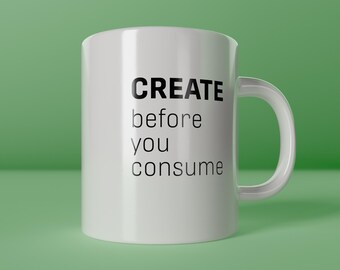 以下が含まれることがあります： 「CREATE before you consume」の黒い文字が入った白いセラミックマグ。マグにはカーブしたハンドルがあり、下部には「create happiness」の文字があります。マグは緑色の表面にあります。