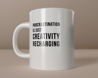 May include: White ceramic mug with a curved handle. The mug features the text "PROCRATINATION IS JUST CREATIVITY RECHARGING" in black and gray lettering. The words "create happiness" are at the bottom.