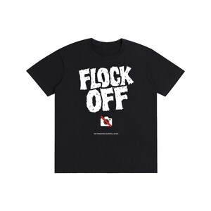 Puede incluir: Una camiseta negra de manga corta con el texto blanco FLOCK OFF en una fuente desgastada. Debajo del texto hay un icono de cámara blanco tachado con una línea roja, seguido del pequeño texto blanco NO TRACKING-SURVEILLANCE centrado en el pecho.