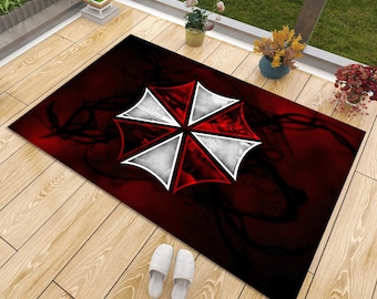 May include: A rectangular floor mat featuring a central graphic of a red and white umbrella-shaped emblem against a dark red and black smoky background. The design includes sharp, geometric segments forming the circular logo pattern.