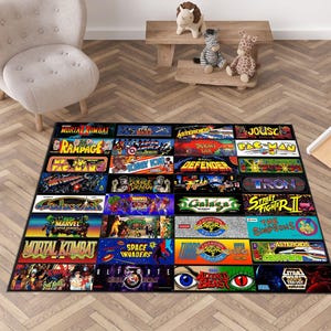 May include: A rectangular area rug featuring a grid of classic arcade game logos and graphics, including titles like Mortal Kombat, Pac-Man, Street Fighter II, Space Invaders, and Star Wars, displayed in vibrant colours against a black background.