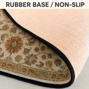 a close-up view of a rug with a textured surface, featuring a floral pattern. The rug appears to have a non-slip base, which is designed to provide stability and prevent slipping on the surface.