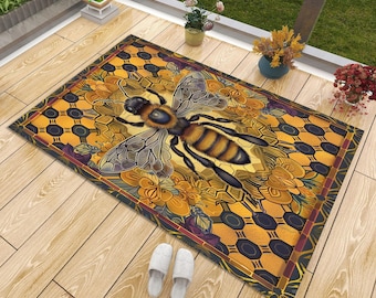 May include: A rectangular floor mat featuring a large, detailed honeybee centered over a golden yellow honeycomb pattern. The design includes stylized orange and yellow floral accents and a dark border, creating a vibrant, nature-inspired graphic print.
