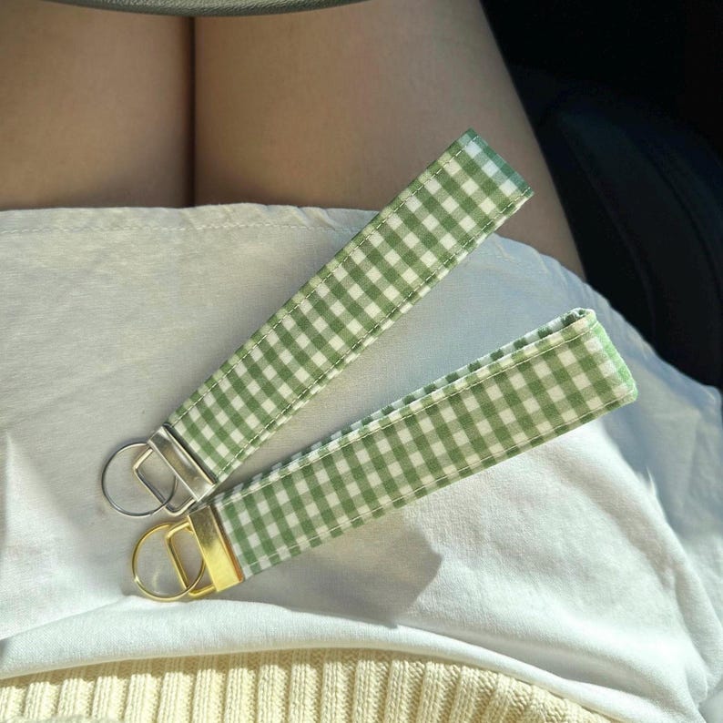 May include: Two green and white gingham keychain straps with gold and silver key rings.