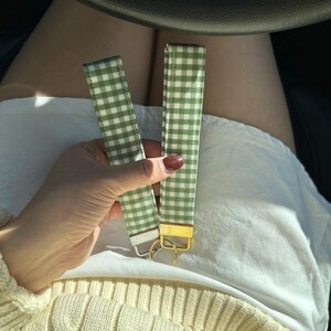 May include: Two green and white gingham keychain straps with gold key rings.