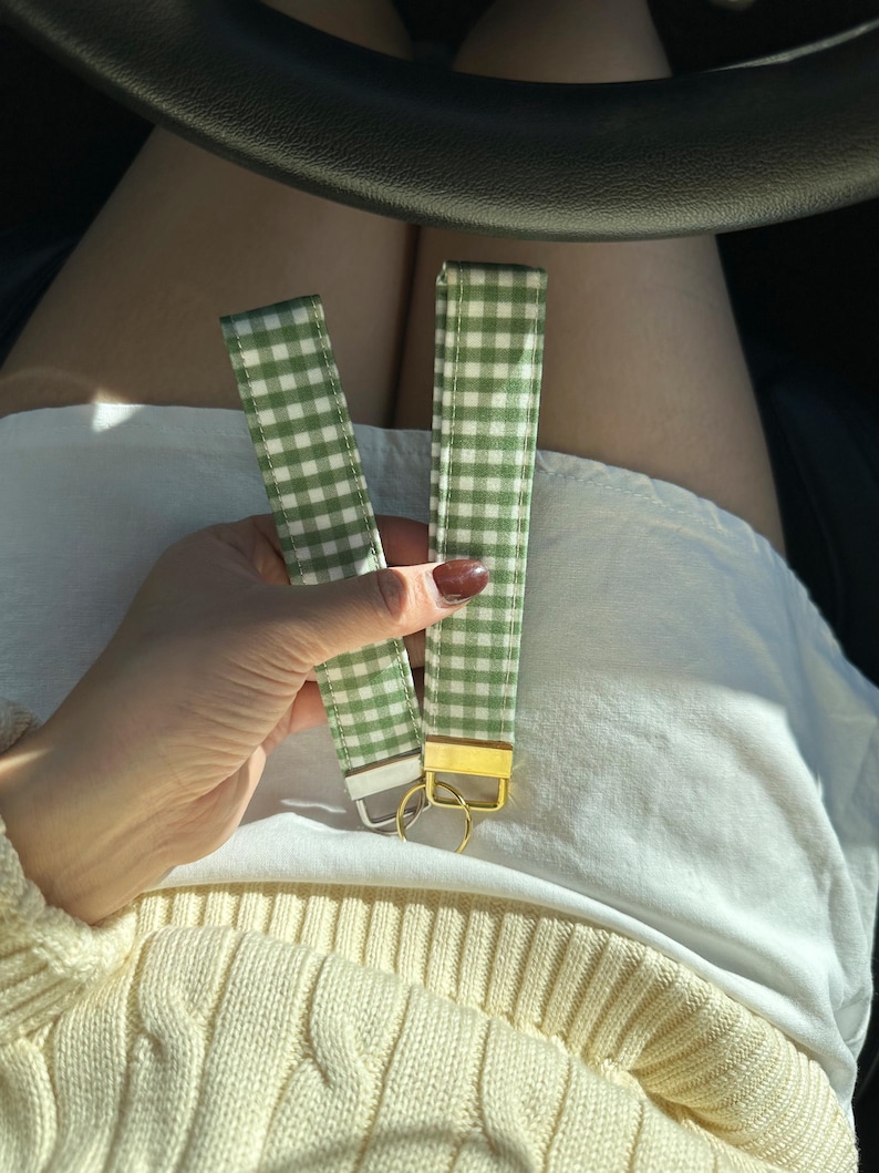 May include: Two green and white gingham keychain straps with gold key rings.