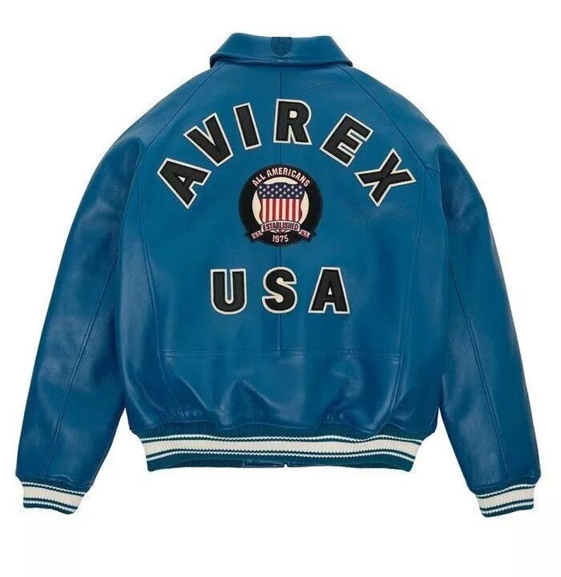 May include: A blue leather jacket with the word "AVIREX" arched across the shoulders. Below the word "AVIREX" is a circular patch with the words "ALL AMERICANS ESTABLISHED 1975" and a graphic of the American flag. The word "USA" is below the patch.