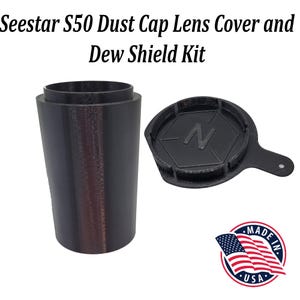 May include: A black dust cap lens cover and dew shield kit for a telescope. The kit includes a cylindrical cover and a hexagonal cap with a handle. The cap has a letter "N" printed on it. The kit is made in the USA.