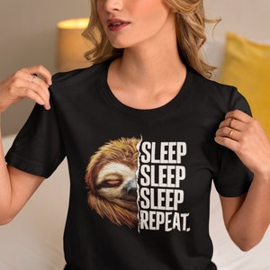 Könnte beinhalten: Ein schwarzes T-Shirt mit einem Grafikdruck eines Faultiers und dem Text "SLEEP SLEEP SLEEP REPEAT."