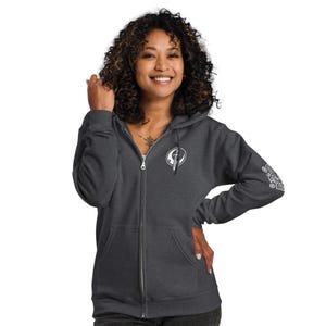 May include: A dark grey zip-up hoodie with a white logo on the front and a white design on the left sleeve. The logo is a circle with a sword and a crescent moon inside.