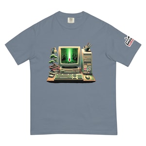 May include: A light blue t-shirt with a retro computer and keyboard graphic. The computer screen displays green code with a red line down the center. The text "sudo" is on the right sleeve of the shirt.