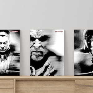 Puede incluir: Tres pósters en blanco y negro con personajes de la serie de videojuegos Tekken. Los pósters se muestran en una estantería de madera.