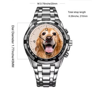 K&ouml;nnte beinhalten: Eine silberfarbene Edelstahlarmbanduhr mit einem Golden Retriever-Portr&auml;t auf dem Zifferblatt. Die Uhr verf&uuml;gt &uuml;ber eine schwarze Tachymeter-L&uuml;nette, einen Zifferblattdurchmesser von 45 mm und eine Gesamtl&auml;nge von 210 mm bei 20 mm Breite.