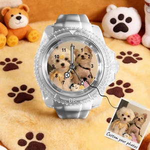 May include: A white analogue wristwatch featuring a custom dial with a photograph of two small dogs. The watch has a textured bezel and a silicone strap. A small square print showing the same dog photograph with the text Custom your photos is attached.