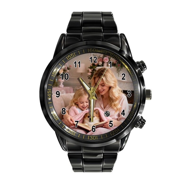 May include: A black metal wristwatch featuring a custom dial with a photograph of a person and a child reading a book with a small dog. The watch has a black link band, a round case, gold-toned hands, and black numerals from one to twelve.