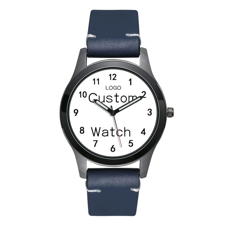 Pu&ograve; includere: Un orologio da polso con cinturino in pelle blu scuro, cassa in metallo nero e quadrante bianco. Il quadrante presenta numeri arabi neri da 1 a 12, lancette nere per ore e minuti, una sottile lancetta dei secondi rossa e il testo "LOGO Custom Watch".