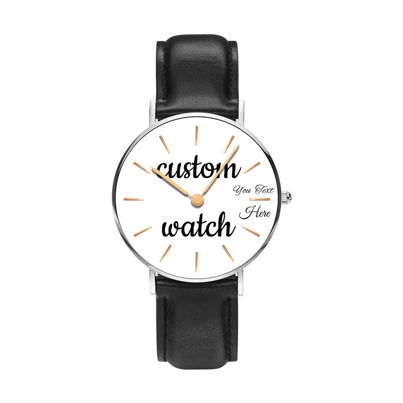 May include: A wristwatch with a black leather strap and a silver-tone circular case. The white dial features gold-tone hour markers, gold-tone hands, and the black text "custom watch" with "You Text Here" printed on the right side of the face.