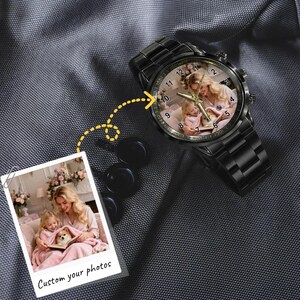 May include: A black metal wristwatch featuring a custom photo dial showing a person and a child with a dog. The watch has a round face with black numbers and gold-toned hands. A separate square photo print shows the same image with the text Custom your photos.