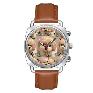 May include: A silver-toned wristwatch with a brown leather strap. The watch face features a repeating pattern of a light-colored puppy with pink cheeks and small pink bows, overlaid with black Roman numerals and three thin black and red hands.