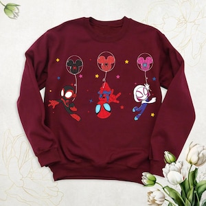 a red sweatshirt with cartoon characters on it