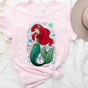 a pink shirt with a picture of a mermaid on it