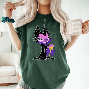 a woman wearing a green shirt with a cartoon character on it