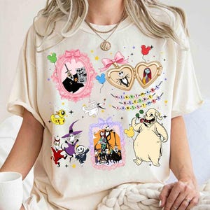 a person wearing a white t-shirt with various cartoon characters and designs, including a skeleton, a pumpkin, and other Halloween-themed elements.